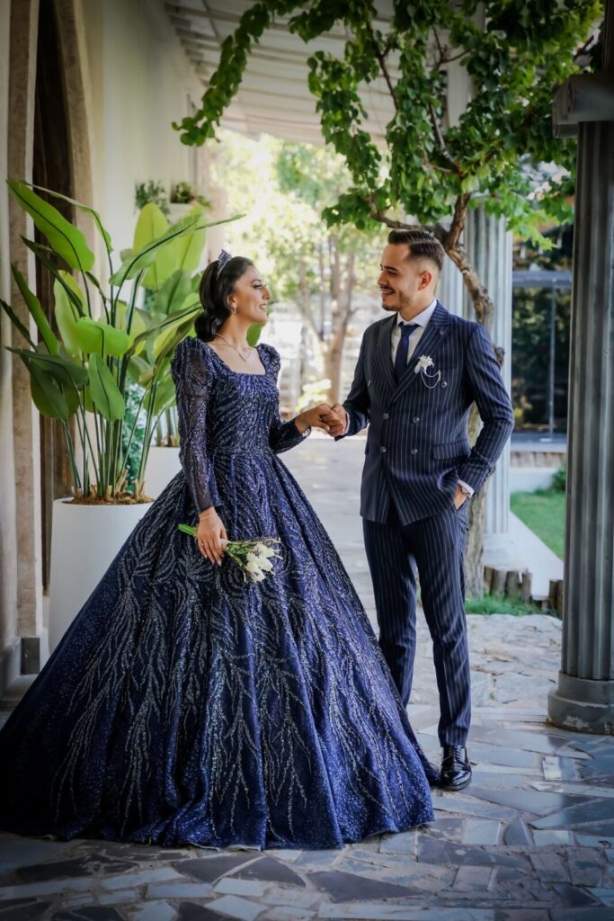 Bride and groom in elegant outfits sharing a joyful moment outdoors
